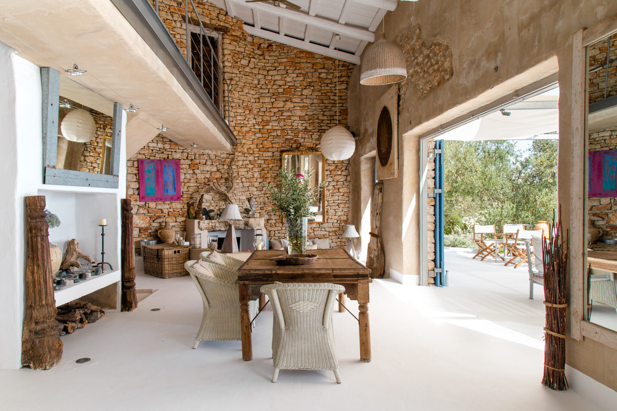 A double height exposed stone living space with rustic Bohemian furnishings